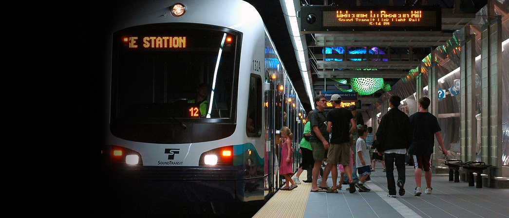 A group of people getting off the light rail at a transit station