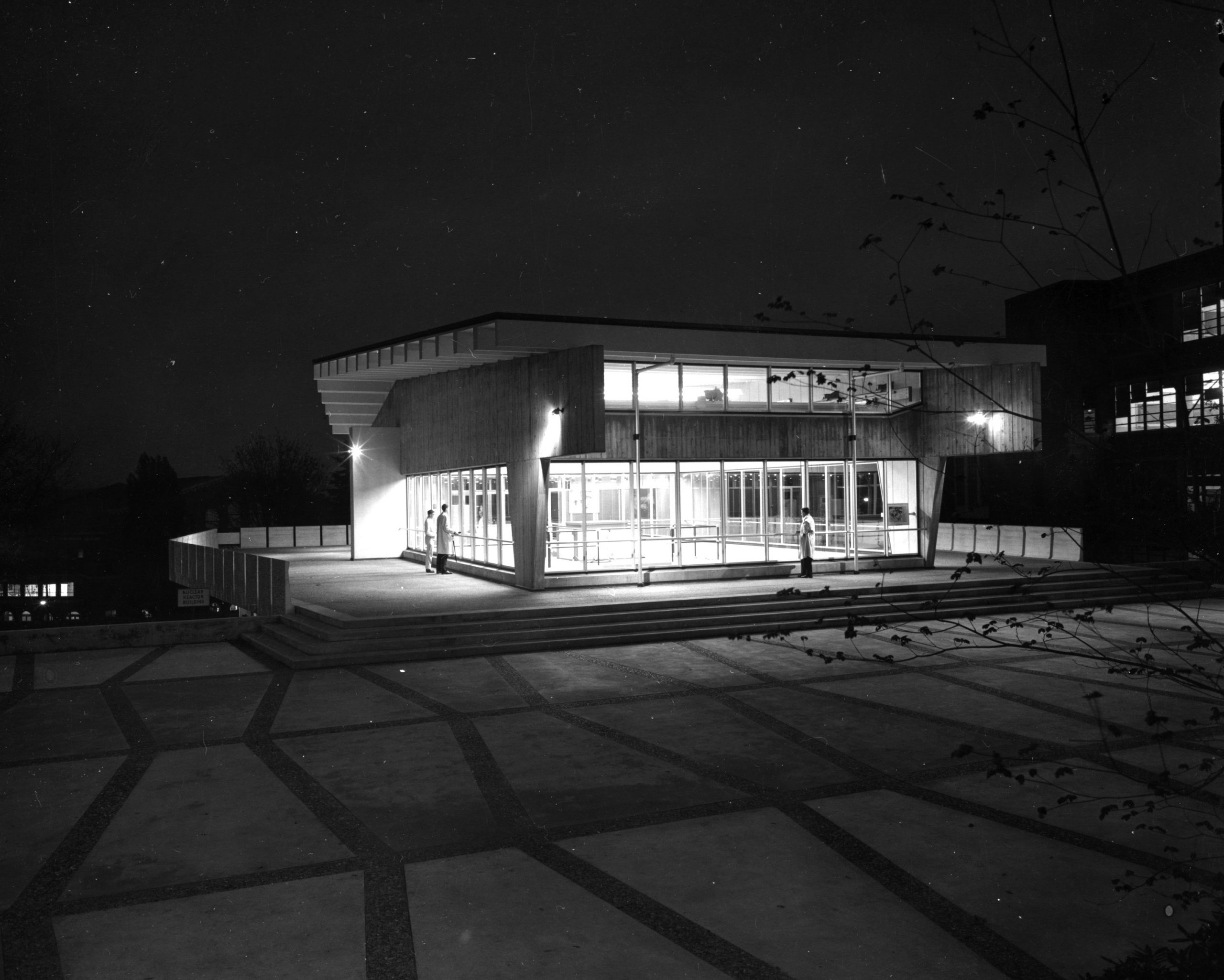 Black and white photo of a building under the night sky, capturing the architectural details in dramatic lighting