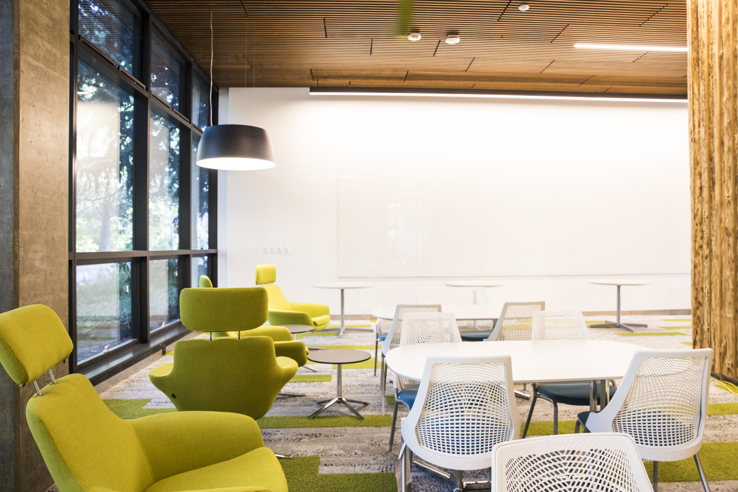 A room with tables and green and white chairs inside the Life Sciences Building