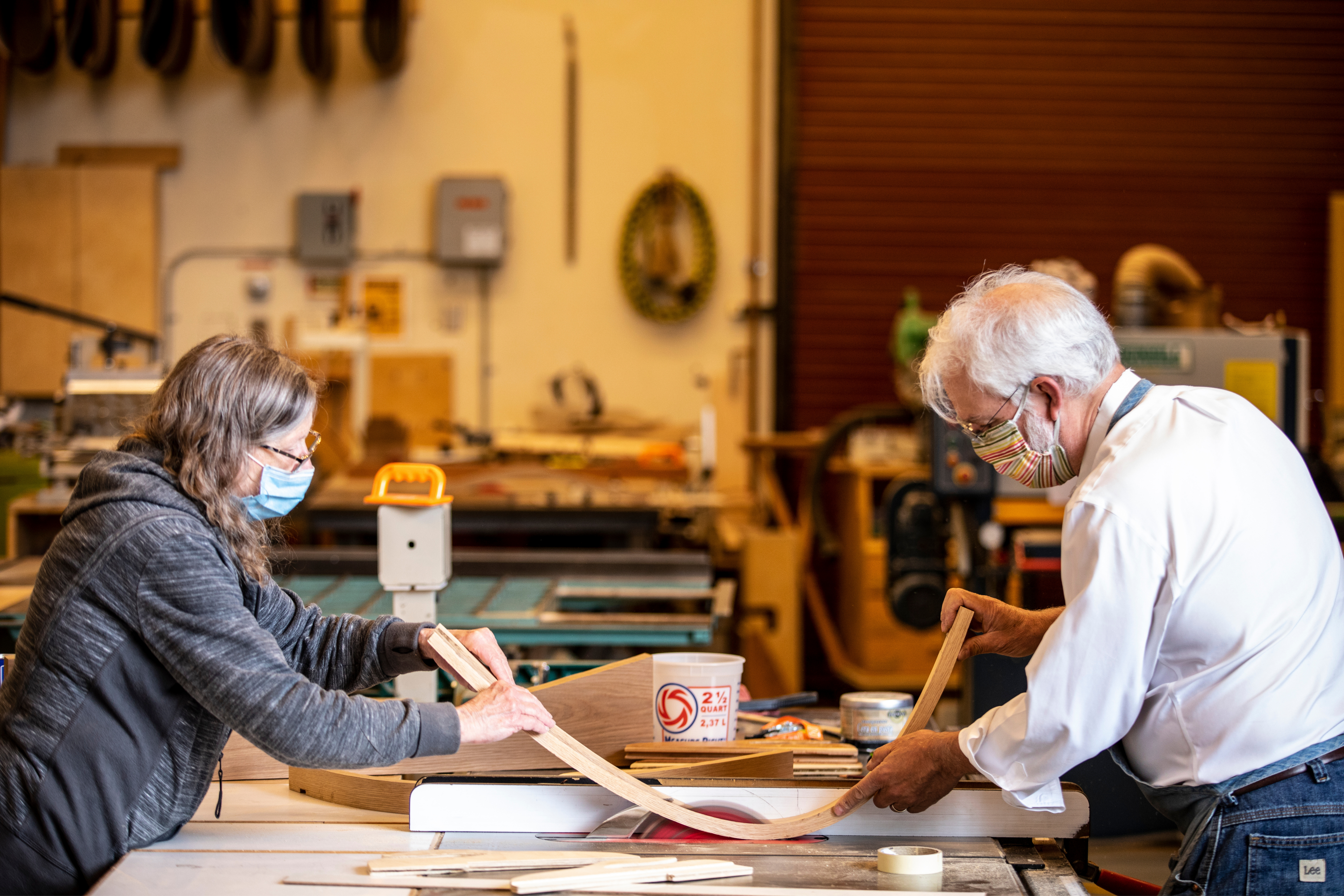 Penny and Professor Griggs crafting a piece of wood