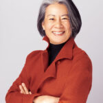 Head shot of Dean Renee Cheng in a red jacket with arms crossed