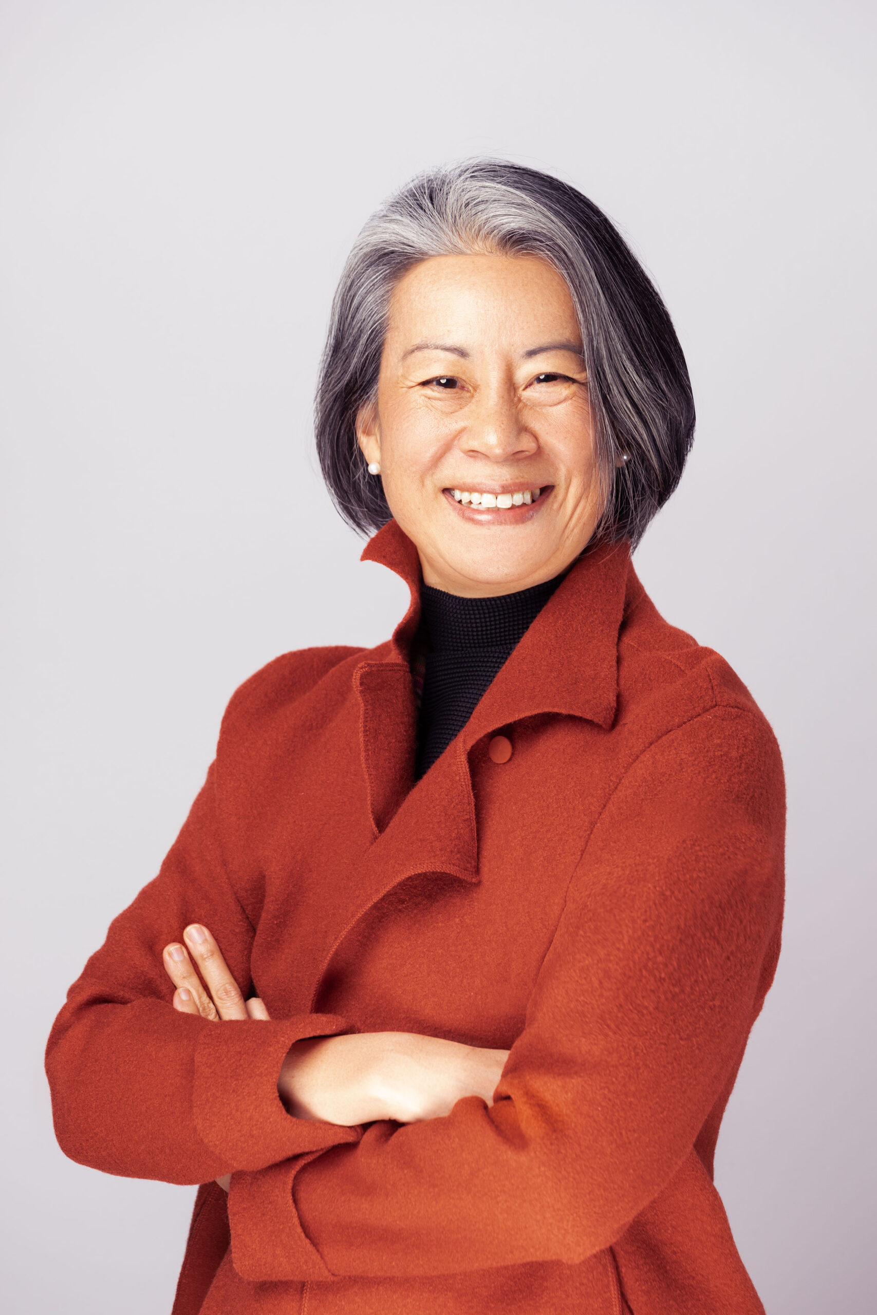 Head shot of Dean Renee Cheng in a red jacket with arms crossed