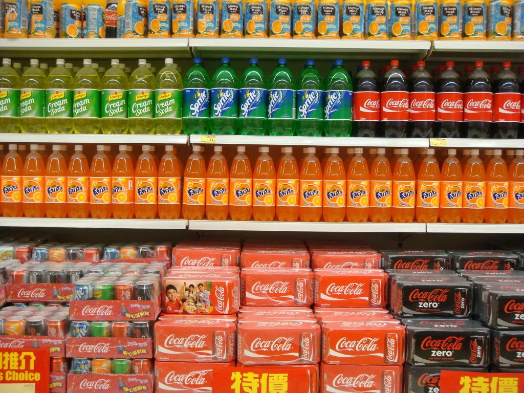 Soda bottles and cans on the store shelves