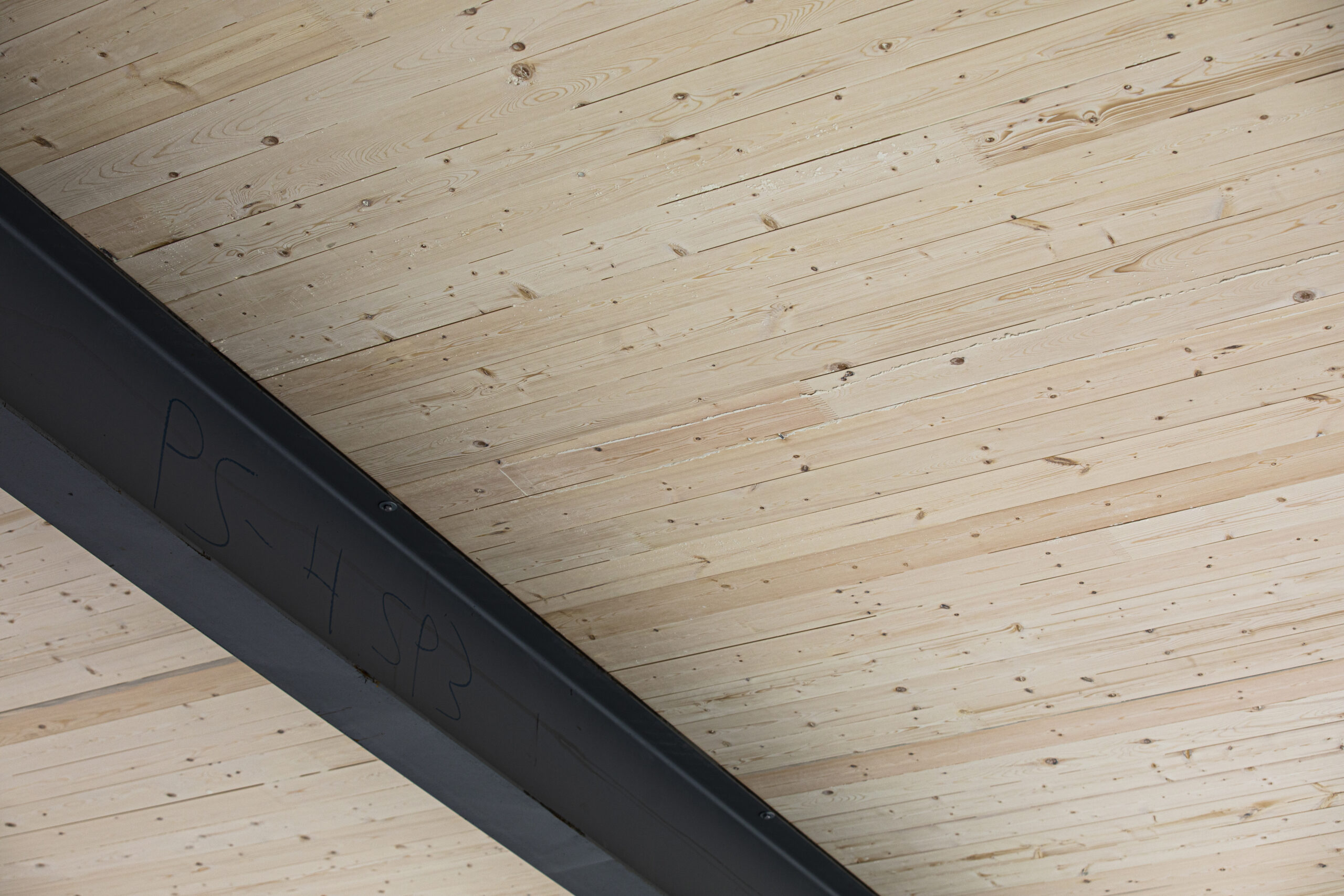 Wood ceiling with a metal beam