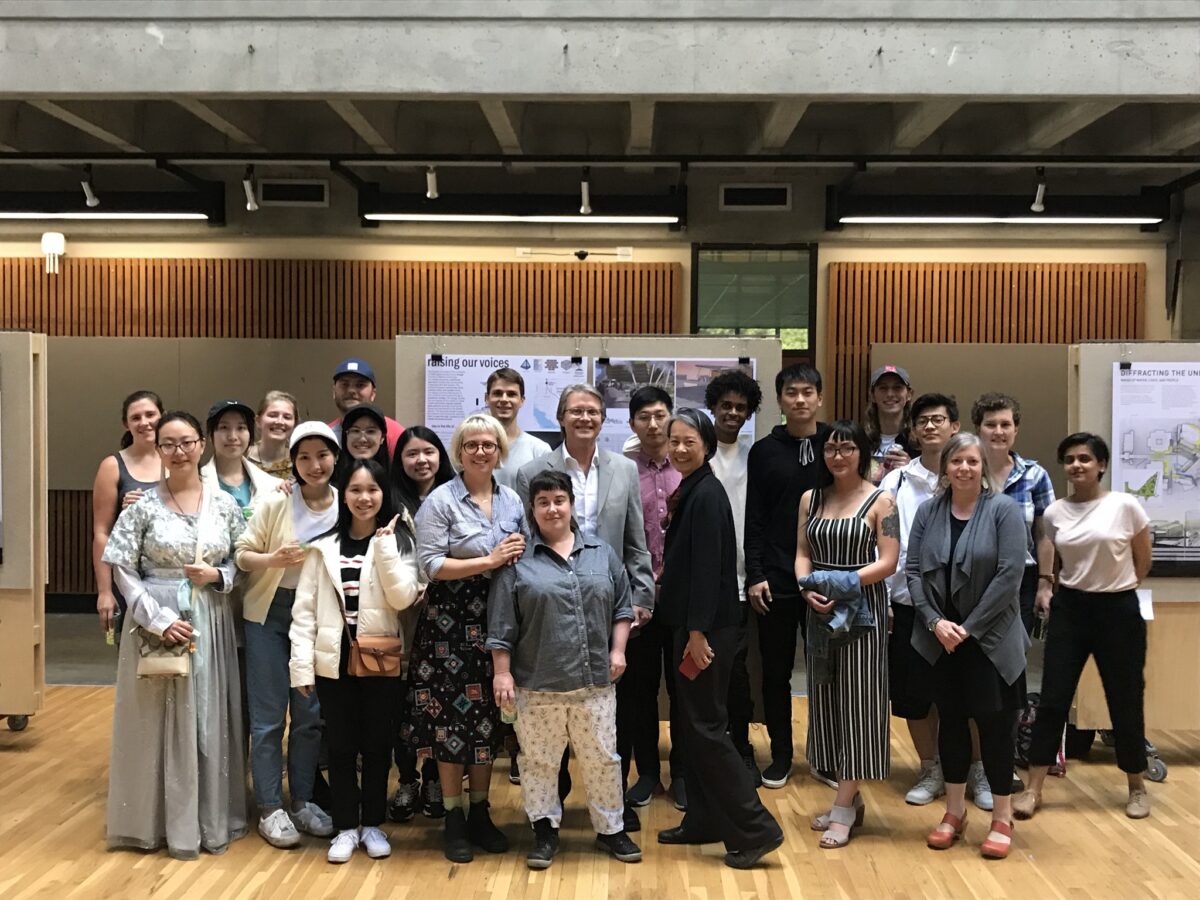 Students and judges gather for a photo in front of project board pin-ups