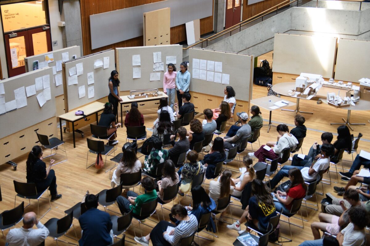 An overhead shot of people watching a presentation at the architecture camp