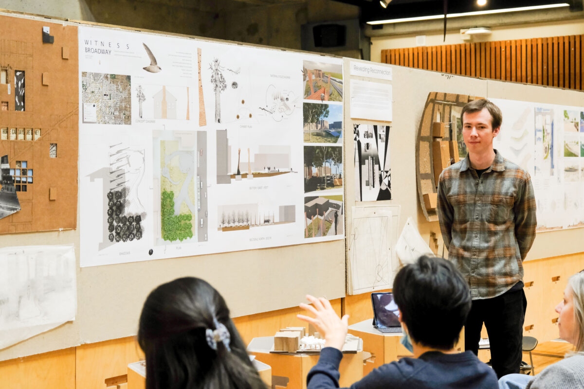 Audience member asking student question during project presentation in Gould Court