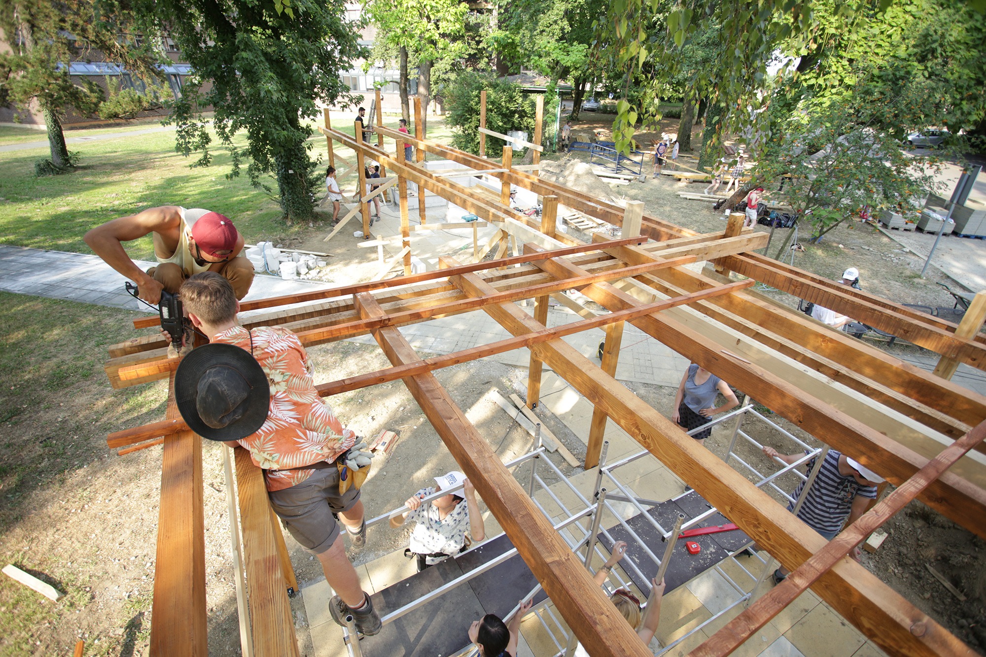 Students working on a wooden structure in a park area