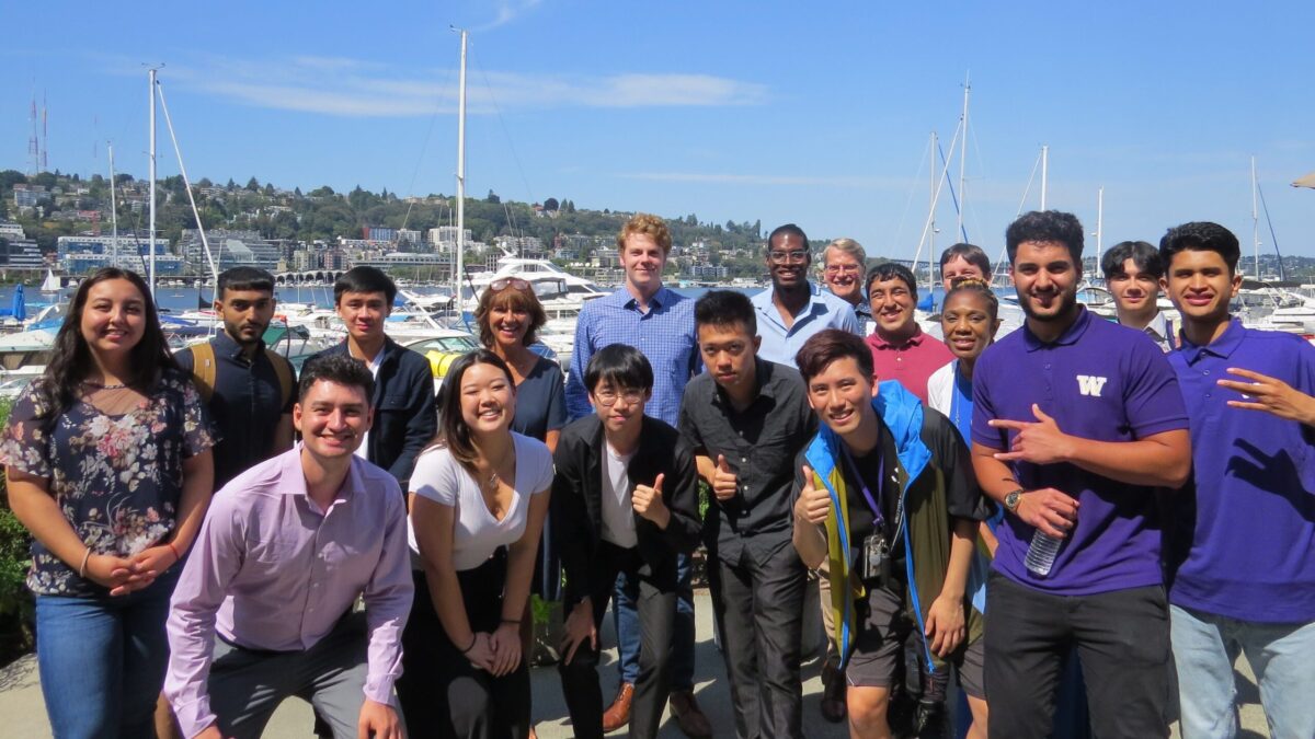 Group of students smiling at a marina