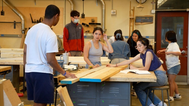 Students work with wood in the fabrication lab