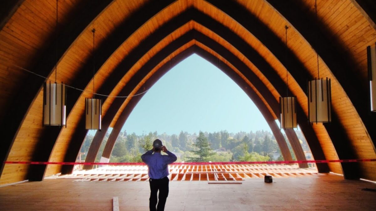 A person standing in front of a large wooden building