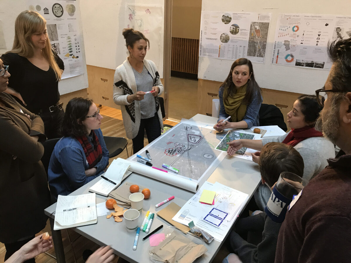 A diverse group of individuals discussing documents at a table