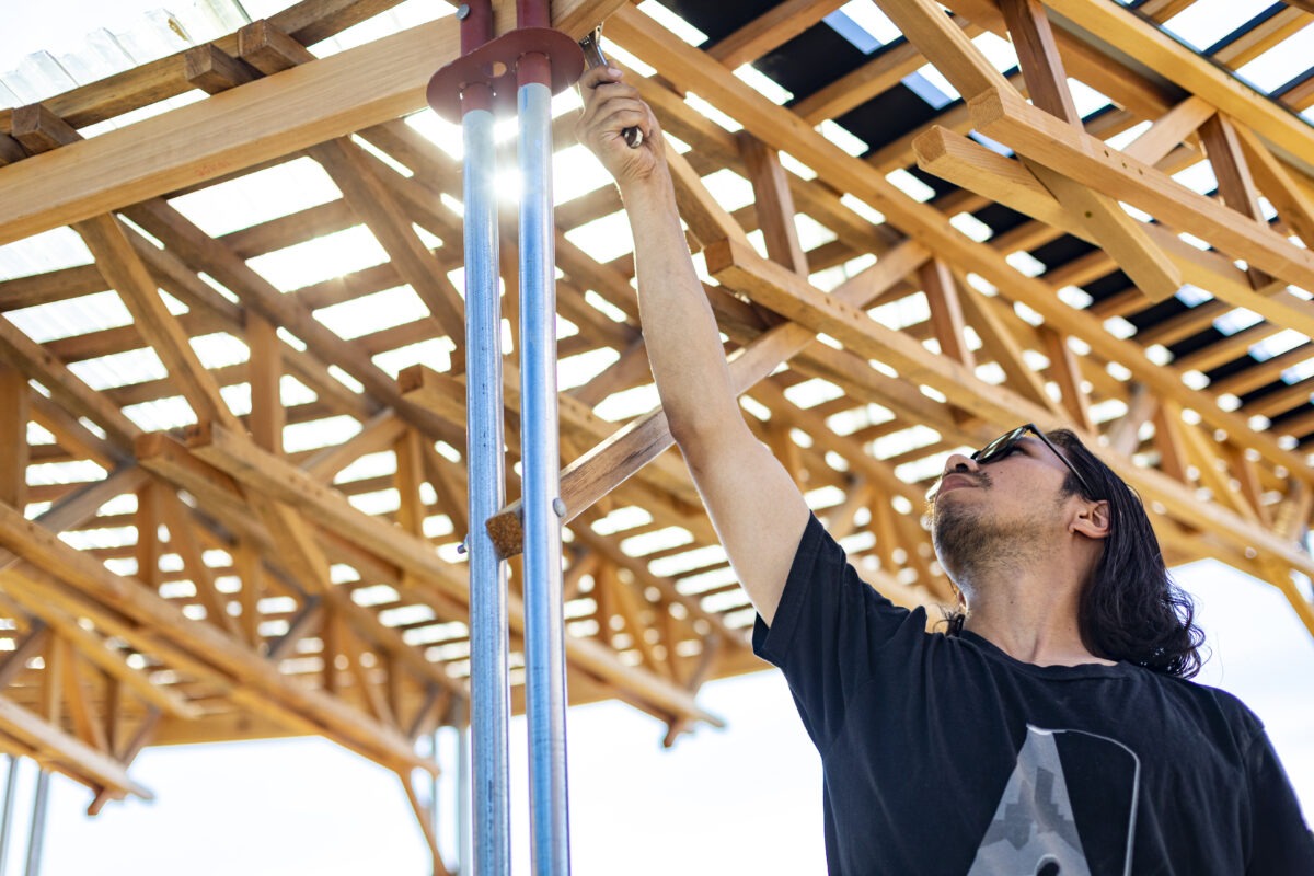 Student using tools on a wooden structure