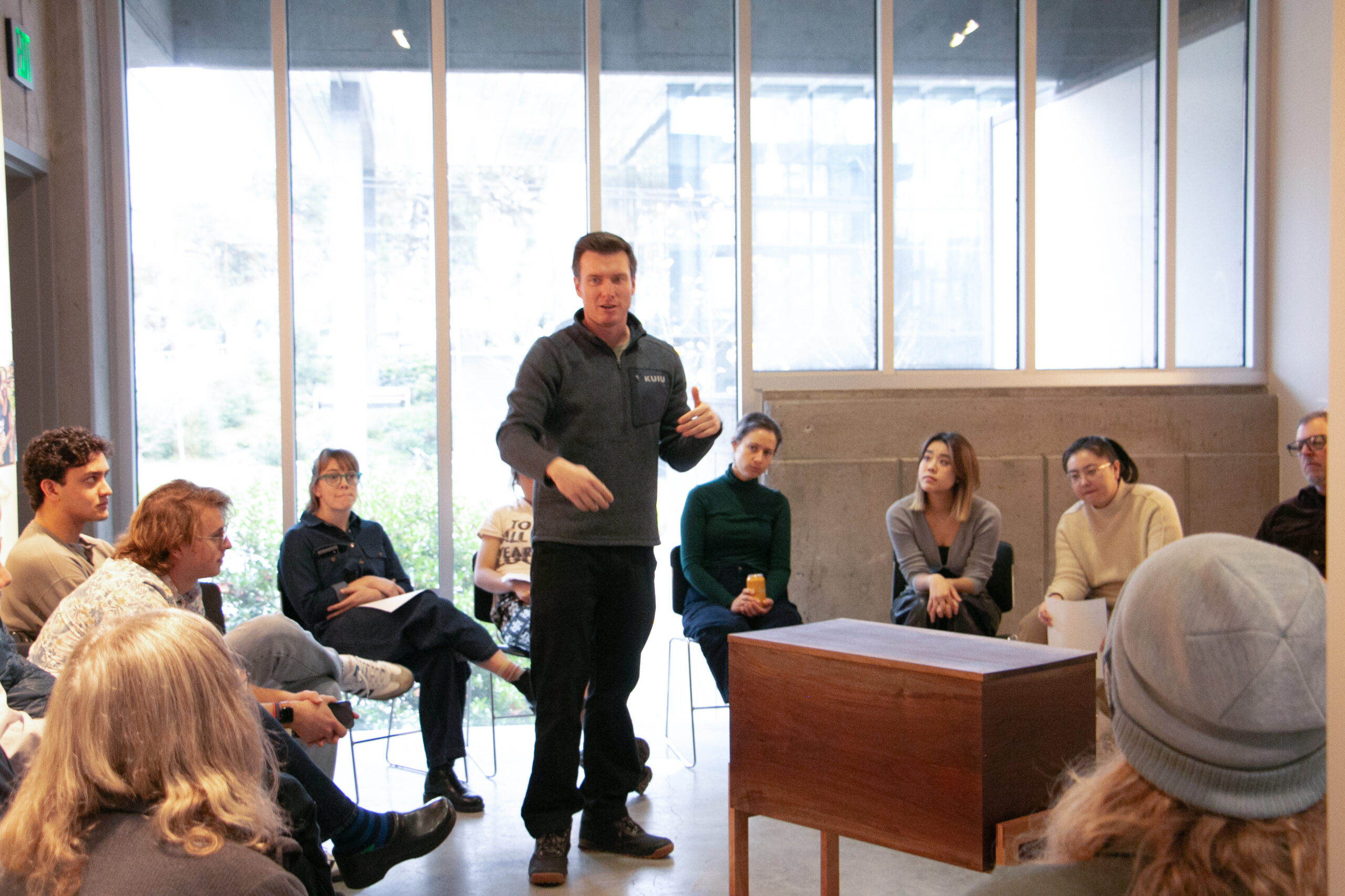 Students listening to another student present their furniture in Gould Gallery
