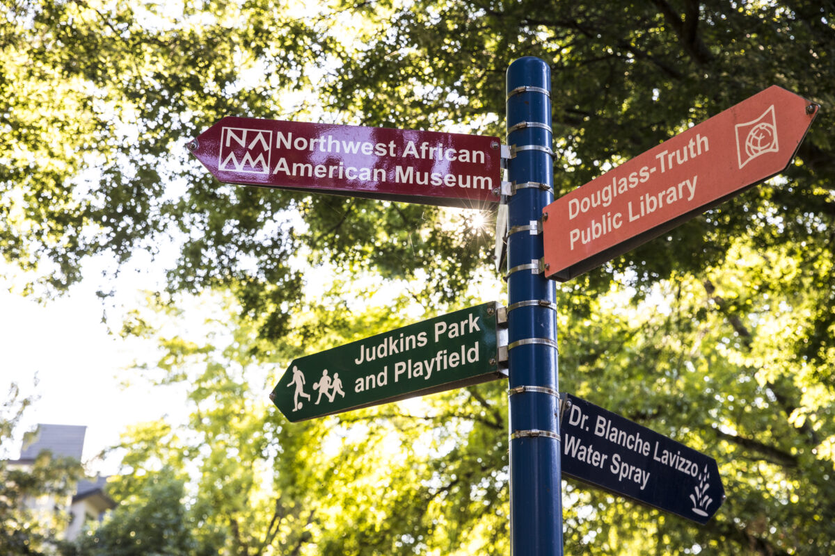 Signs pointing toward various landmarks in Africa Town, including Judkins Park, the NW African American Museum, and the Douglas Truth Public Library