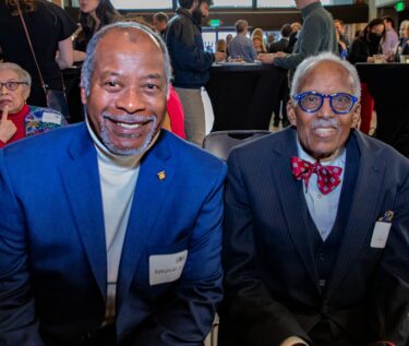 Two men sitting and smiling