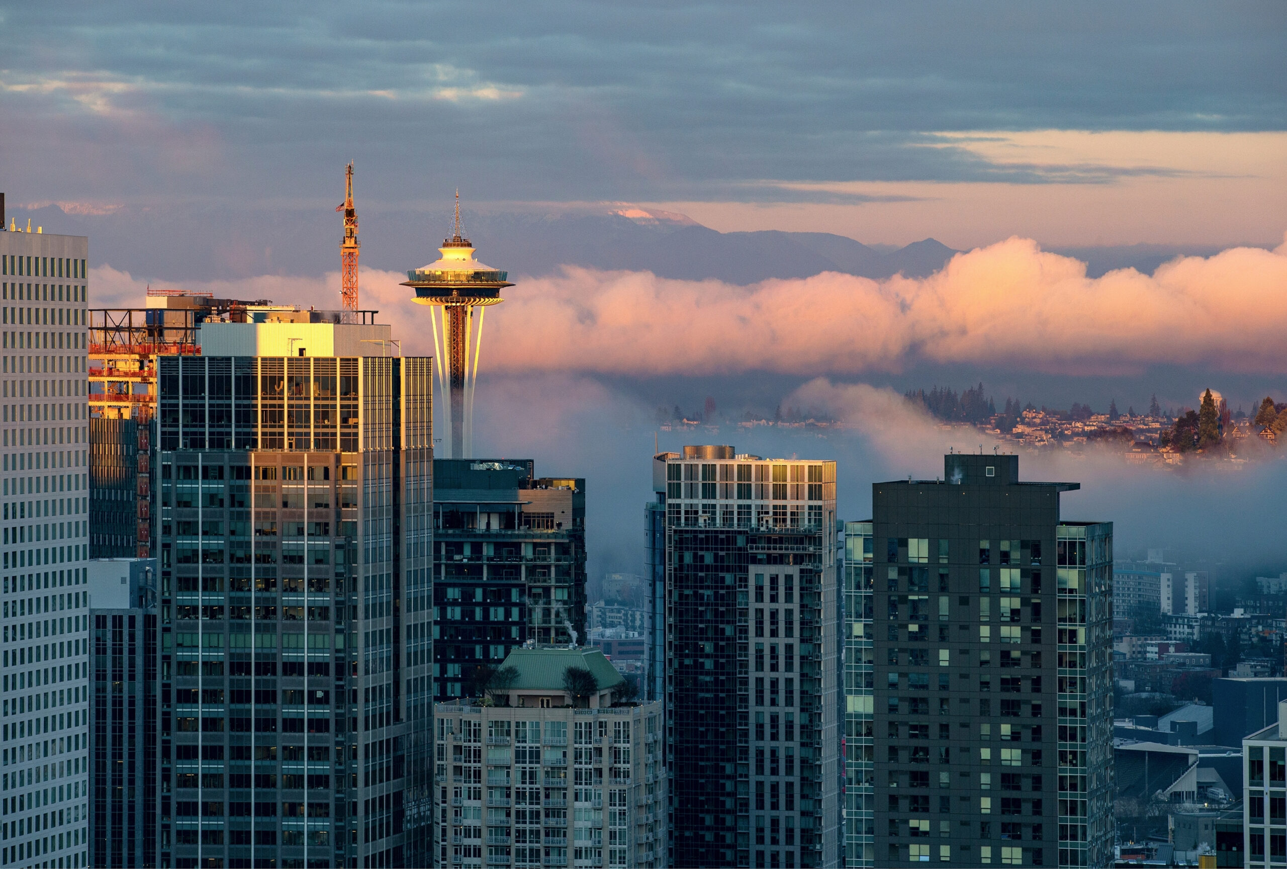 Space Needle with cranes and apartment buildings