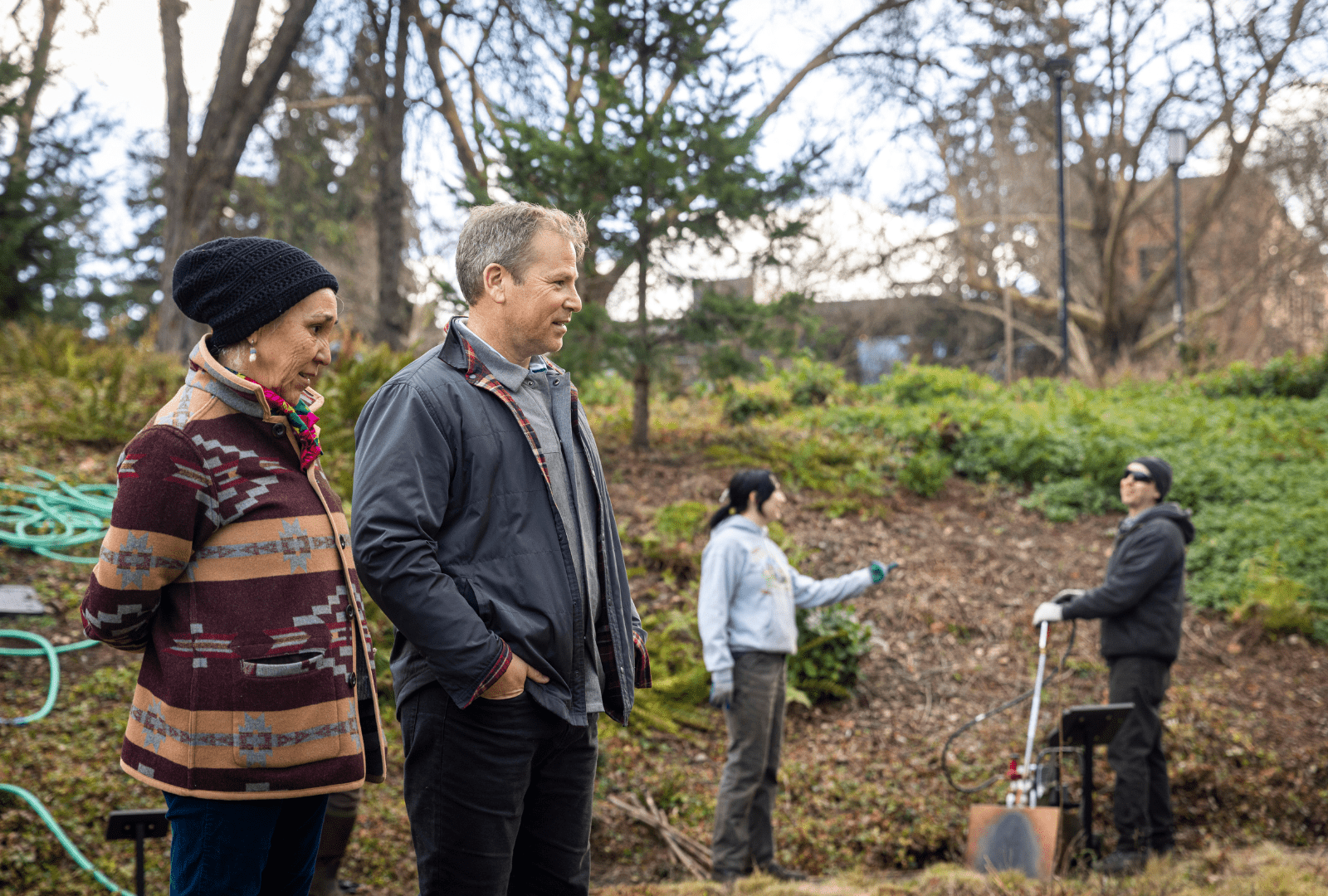 Ken Yocom and Polly Olsen stand together in Burke Meadow during a cultural burn, surrounded by smoke and open grassland.