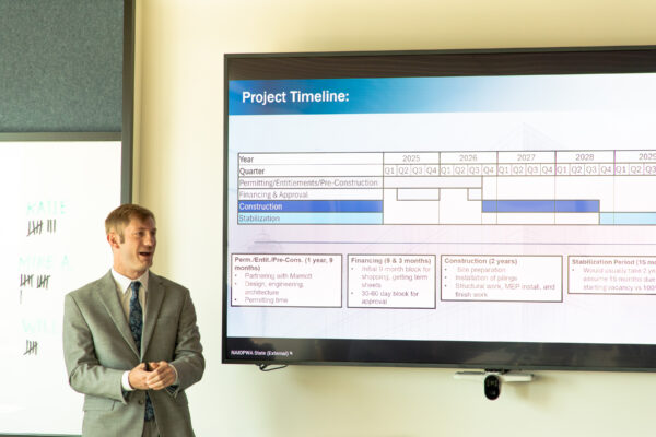 Student speaking in front of a screen