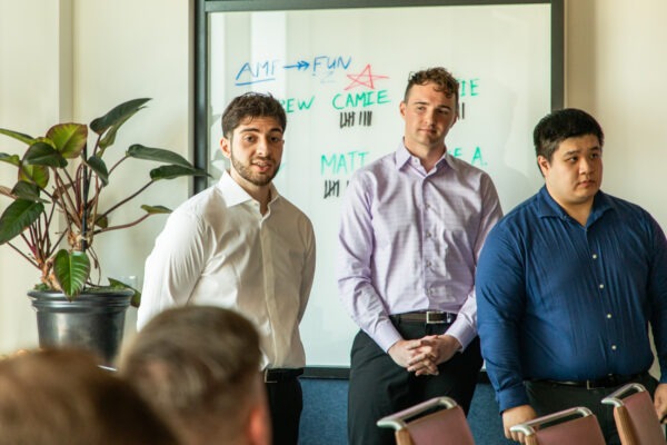 Three students speaking to a room