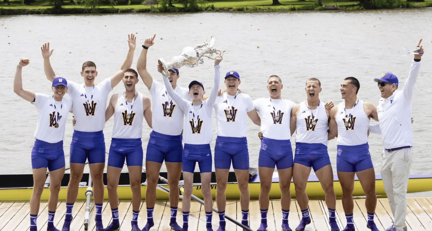 Team of rowers cheering with trophy