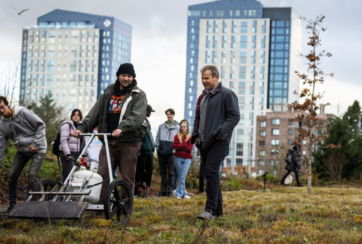 Ken Yocom walks beside landscape architecture master’s student Eric Alipio, who is operating a torch wagon during a cultural burn at Burke Meadow.