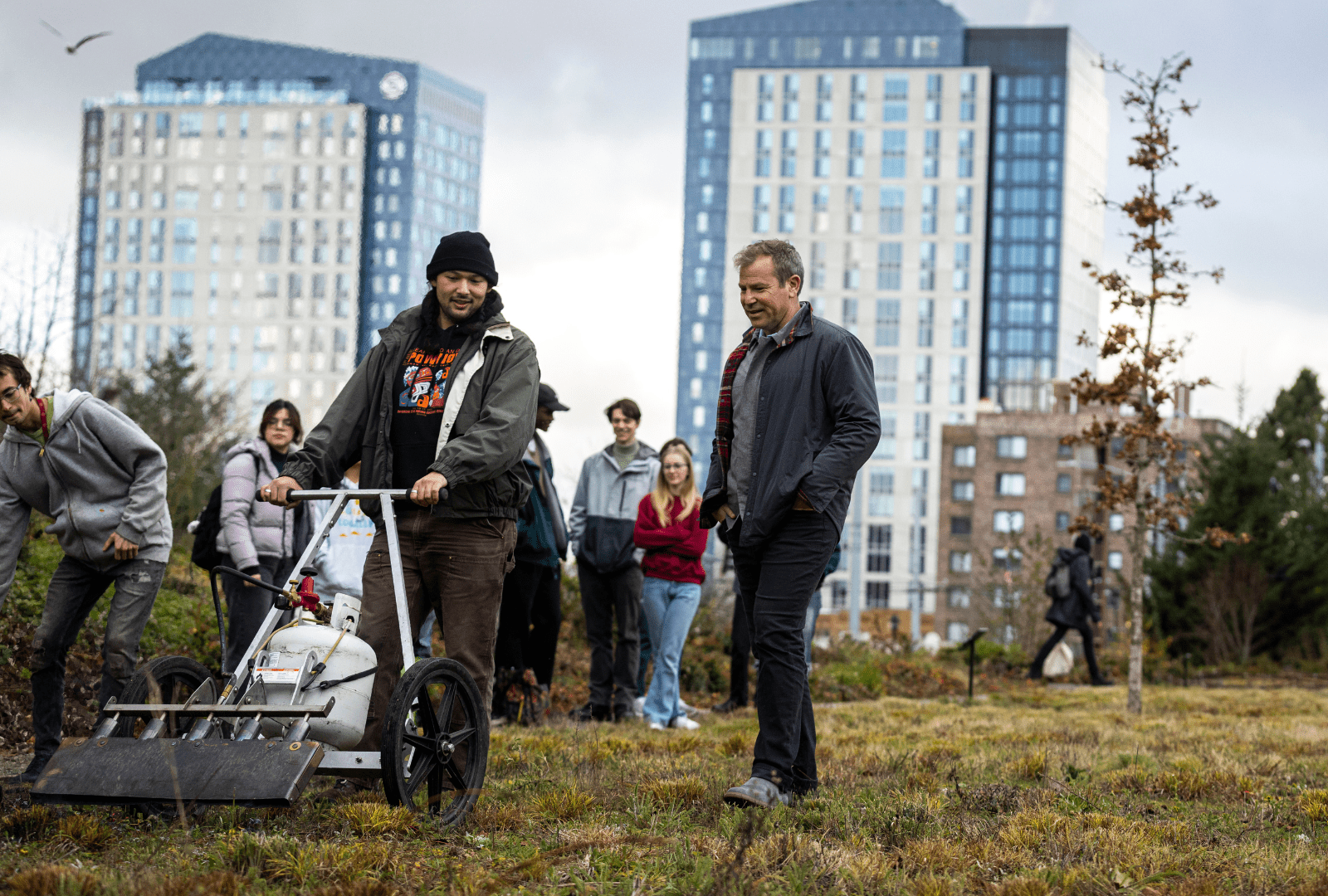 Ken Yocom walks beside landscape architecture master’s student Eric Alipio, who is operating a torch wagon during a cultural burn at Burke Meadow.