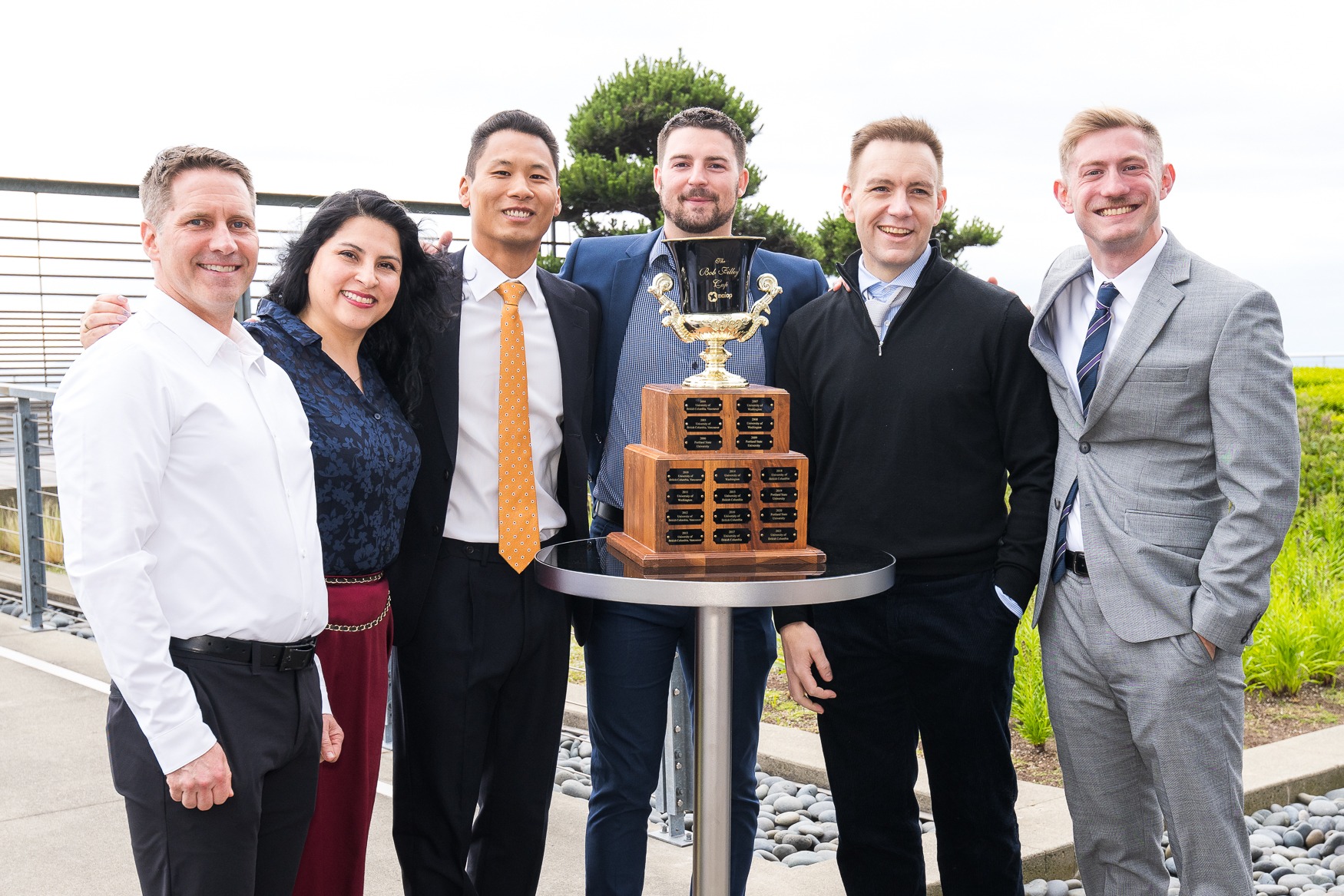 Students posing around a trophy