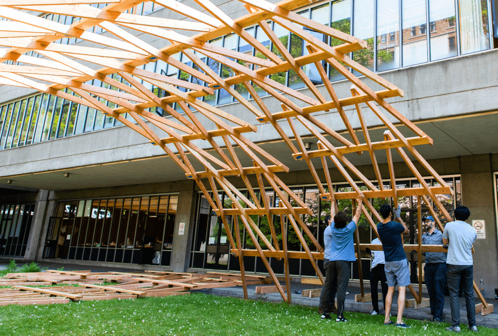 Students building wooden structure in front of Gould Hall