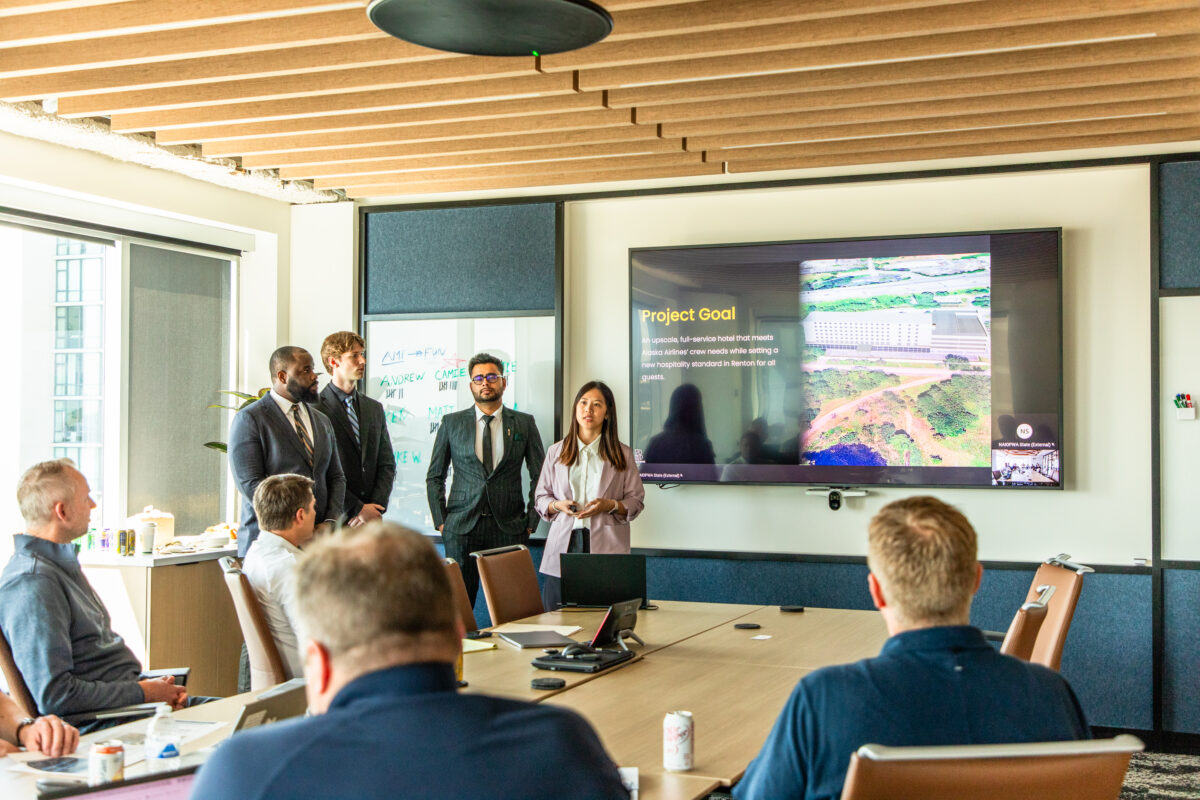 Students standing in front of a group of people giving presentations