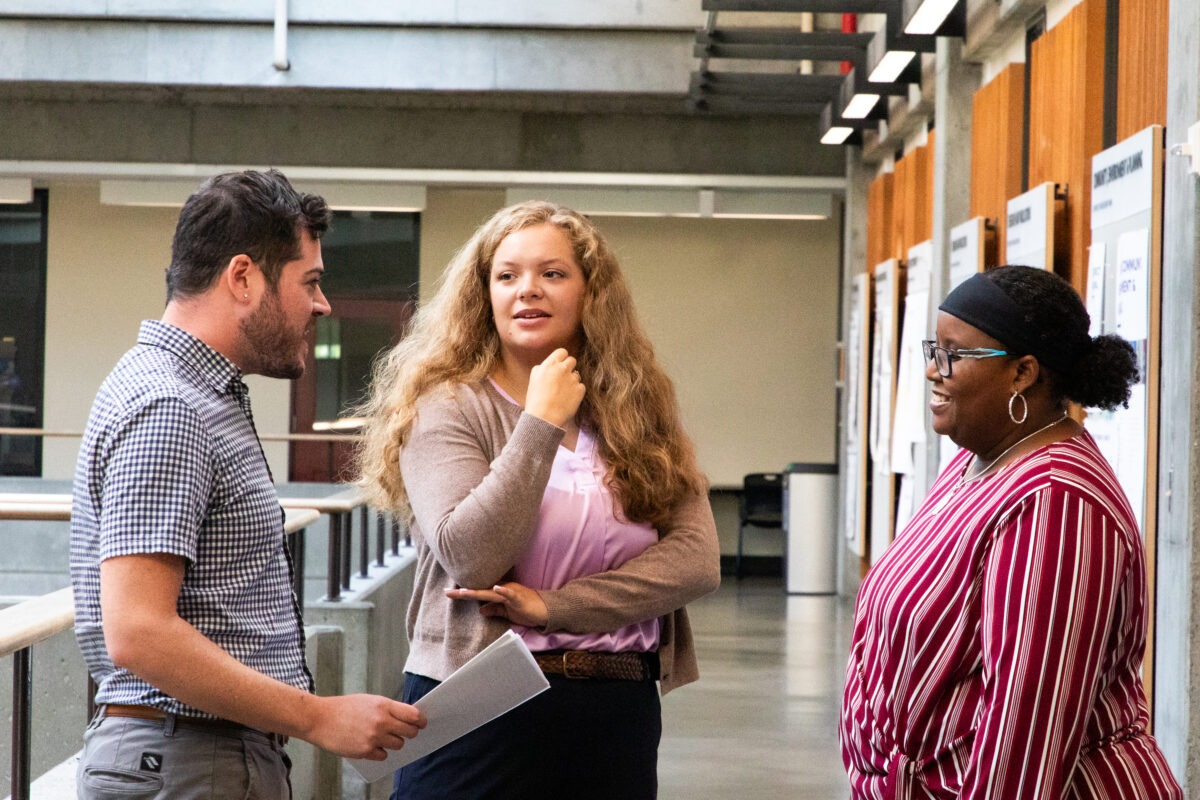 Student chatting with advisors in Gould Hall