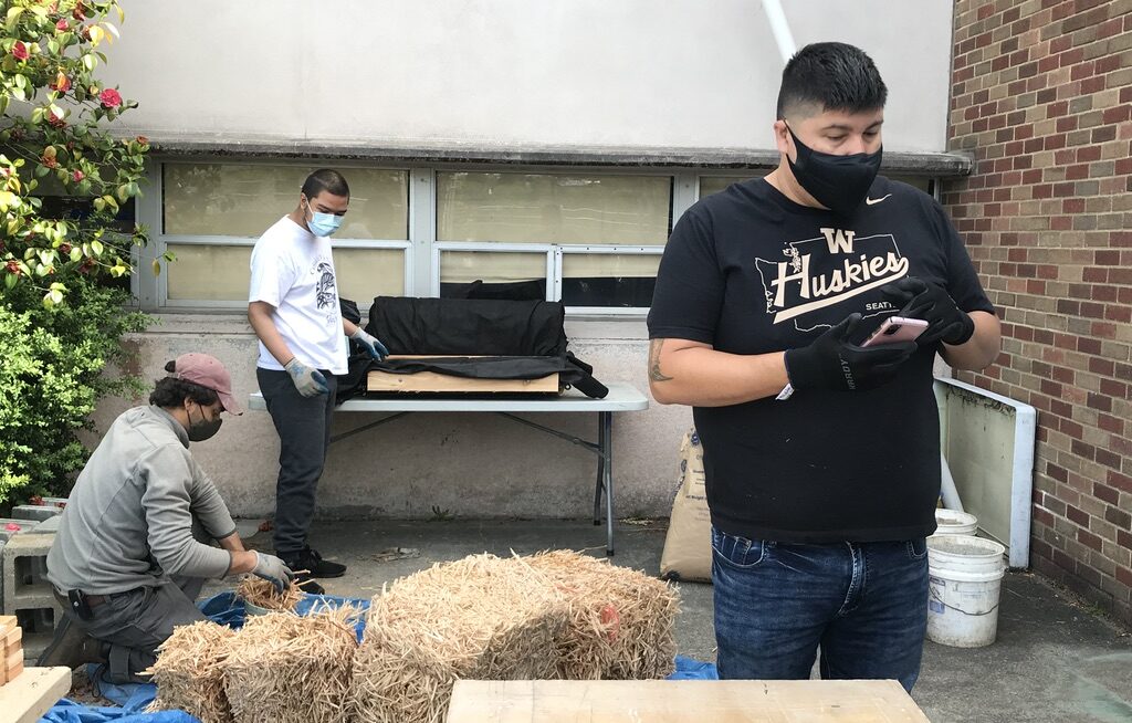 Three people working together outside. Lehman and others work to retrofit urban shorelines with sweetgrass — a plant with cultural significance for many Indigenous communities — to improve water quality, increase salmon habitat and restore keystone species.