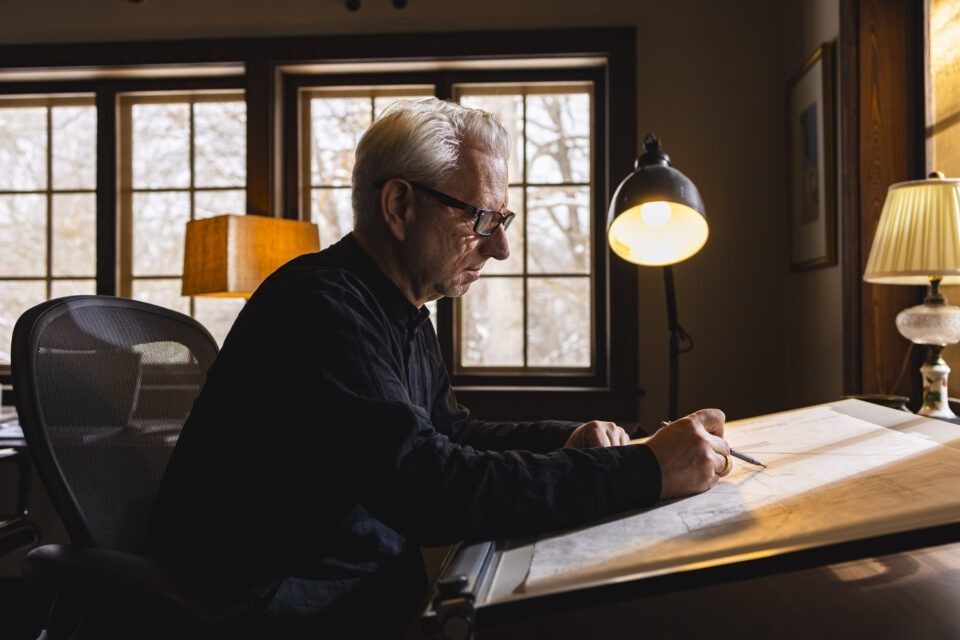 Robert Hutchison working at his drafting table during the Loghaven residency, 2024. Photo / Loghaven