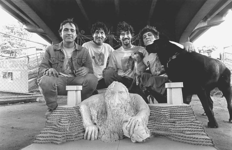 People posing with a model of a troll