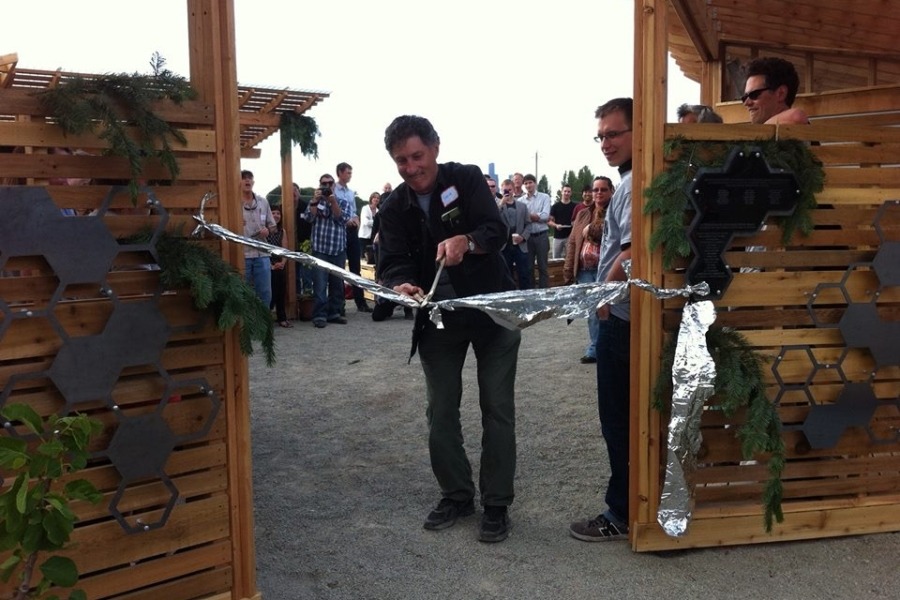 Steve Badanes cutting ribbon between two wooden structures