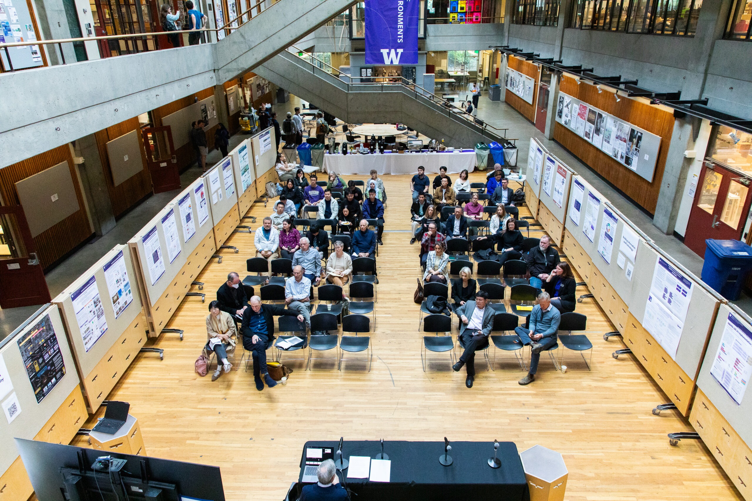 People sitting in rows in Gould Court surrounded by poster boards