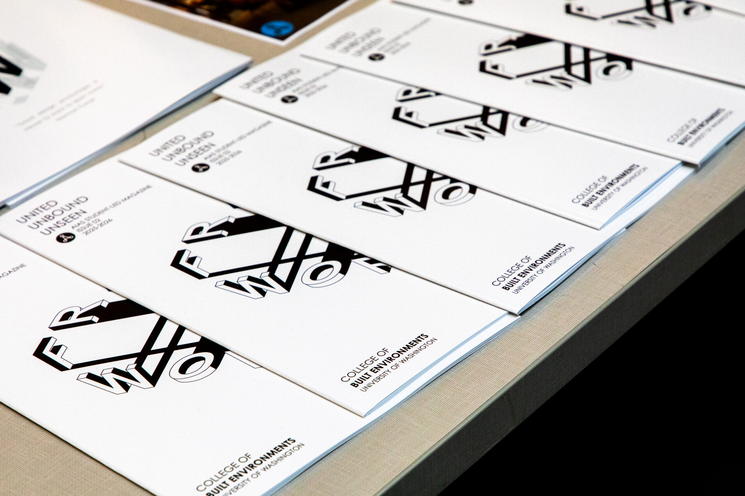 Printed FrameWorks exhibition programs arranged on a table.